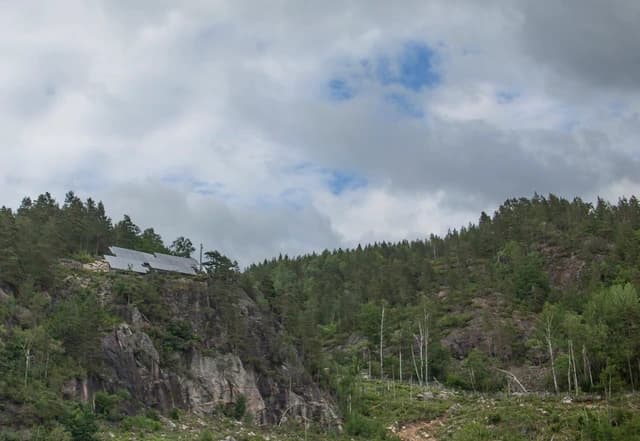 Vidvinkel av Konsmo-anlegget i fjellterrenget med skog